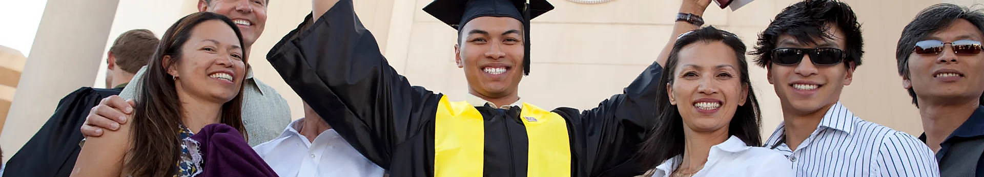 Smiling student celebrates with proud family members at a graduation ceremony