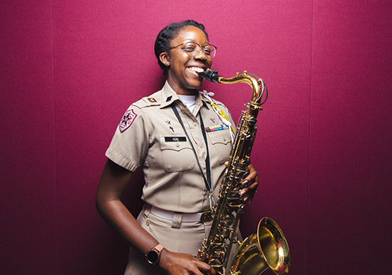 A member of the Fightin' Texas Aggie Band holds a saxophone.
